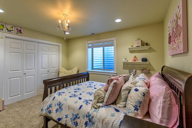 bedroom with a textured ceiling, carpet floors, an inviting chandelier, and a closet