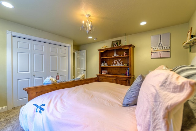 bedroom with light carpet, a closet, and a notable chandelier