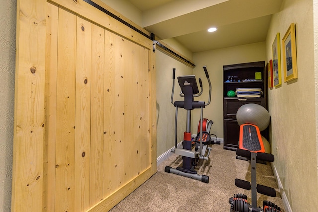 workout room featuring carpet and a barn door