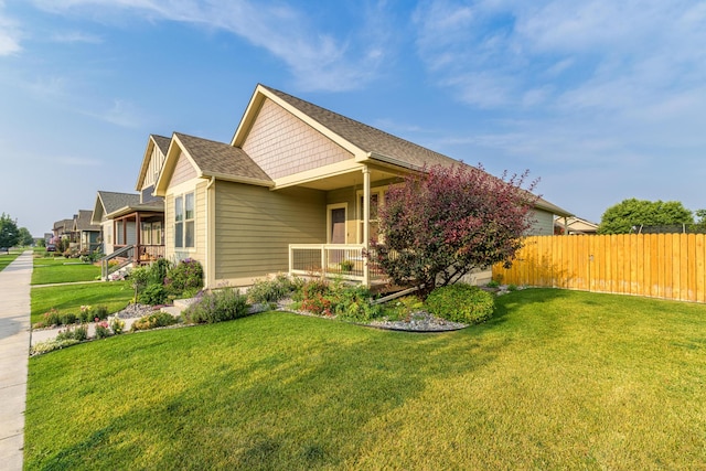 view of side of property featuring a porch and a lawn