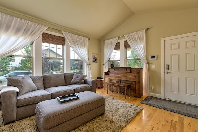 living room with light hardwood / wood-style floors and vaulted ceiling