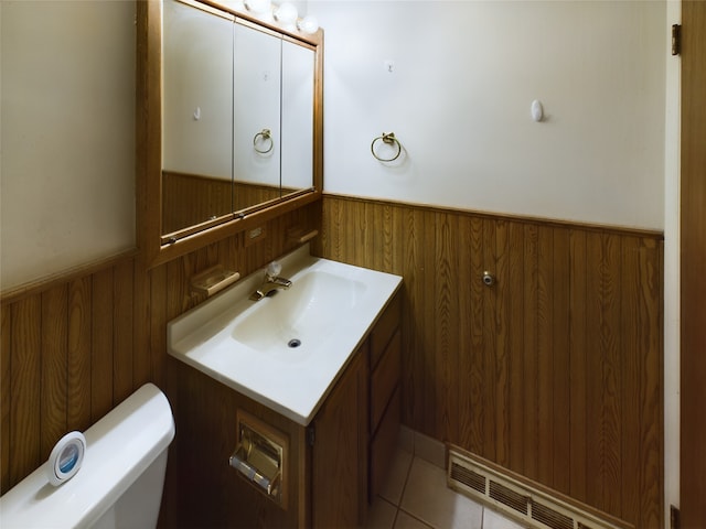 bathroom with tile patterned flooring, vanity, toilet, and wooden walls