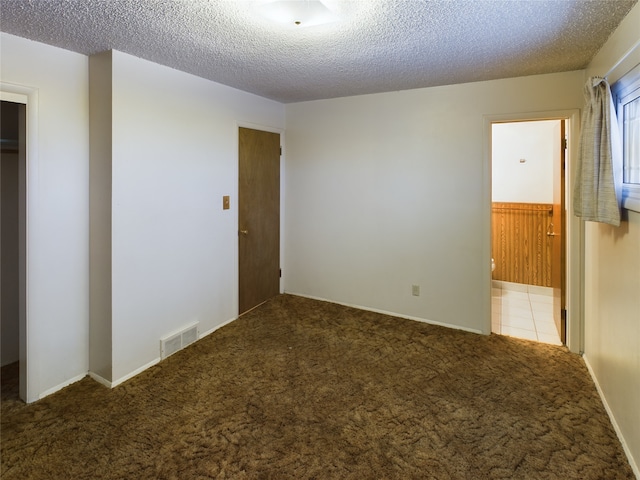 unfurnished bedroom featuring carpet flooring, a textured ceiling, and a closet