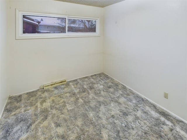 carpeted empty room with a textured ceiling