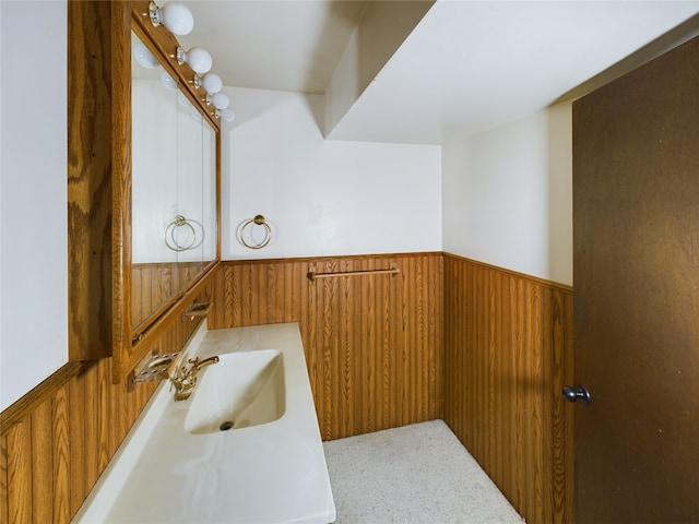 bathroom featuring vanity and wooden walls