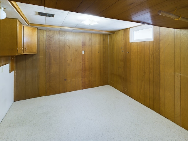 basement with carpet flooring and wooden walls