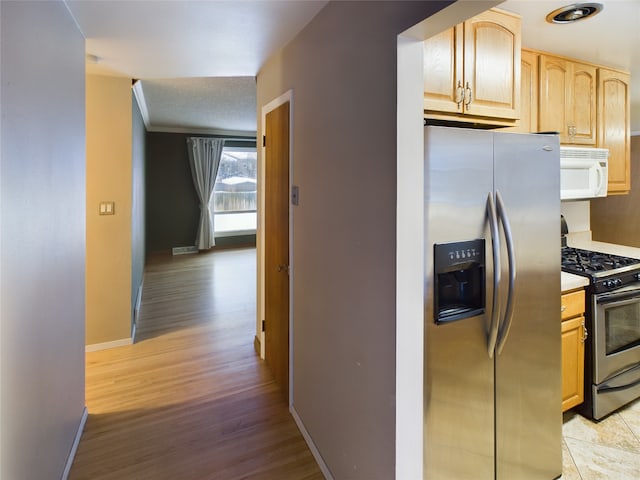 kitchen featuring stainless steel fridge with ice dispenser, light brown cabinets, light hardwood / wood-style flooring, and range with gas stovetop