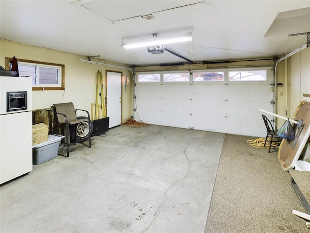 garage with white fridge and a garage door opener