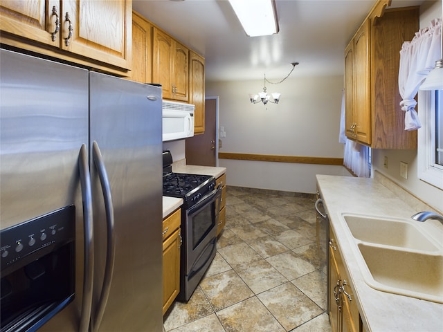 kitchen with stainless steel refrigerator with ice dispenser, a notable chandelier, black range oven, and sink