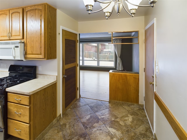 kitchen with decorative light fixtures, black gas stove, and an inviting chandelier