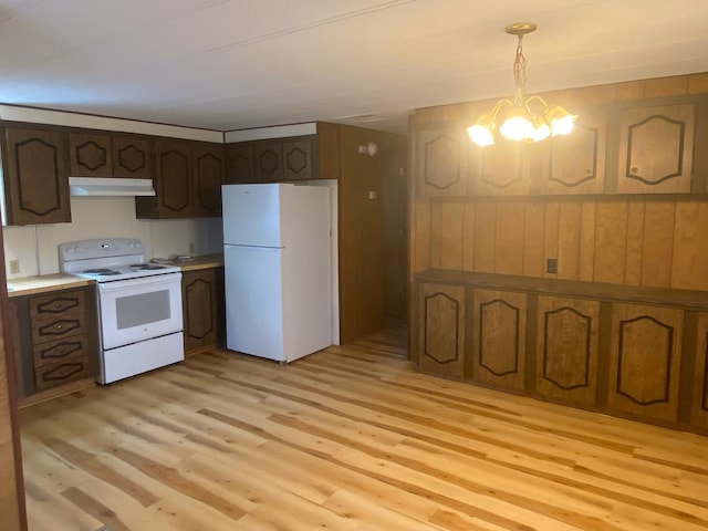 kitchen featuring a notable chandelier, light wood-type flooring, white appliances, and hanging light fixtures