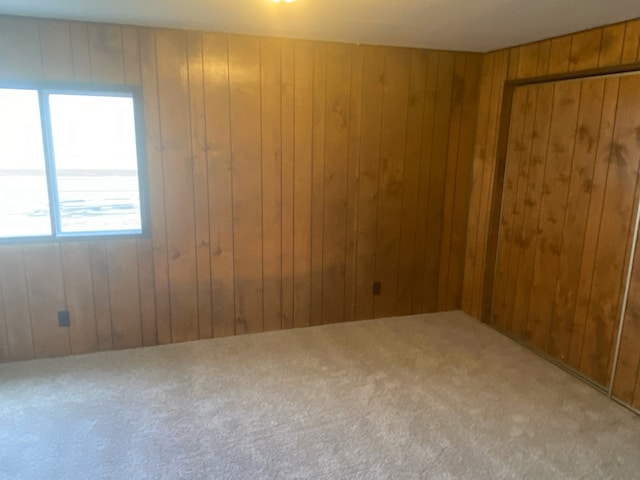 carpeted empty room with wooden walls