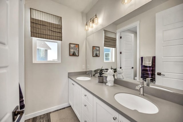 bathroom featuring hardwood / wood-style floors, vanity, a healthy amount of sunlight, and toilet