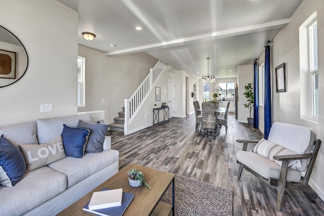 living room with hardwood / wood-style floors, beamed ceiling, and a chandelier