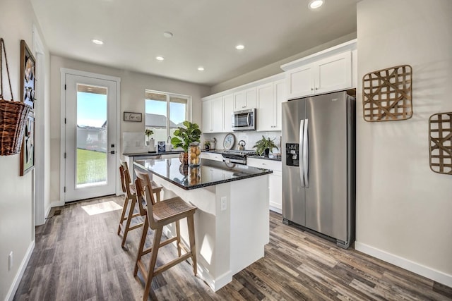 kitchen with white cabinetry, a center island, a healthy amount of sunlight, and appliances with stainless steel finishes