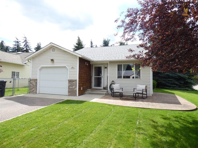 view of front facade featuring a patio area, a garage, and a front lawn