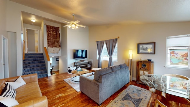 living room featuring ceiling fan, wood-type flooring, and lofted ceiling