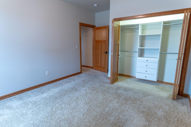 unfurnished bedroom with light colored carpet and a closet