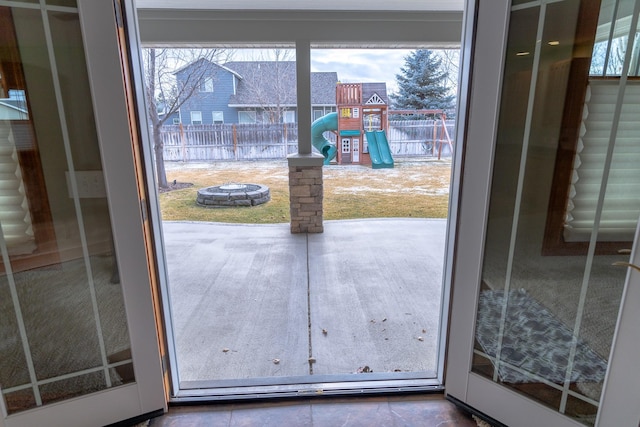 doorway with a wealth of natural light and dark tile patterned flooring