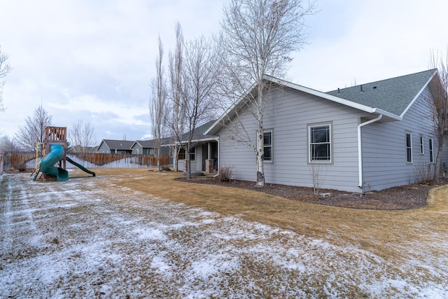 snow covered property with a playground