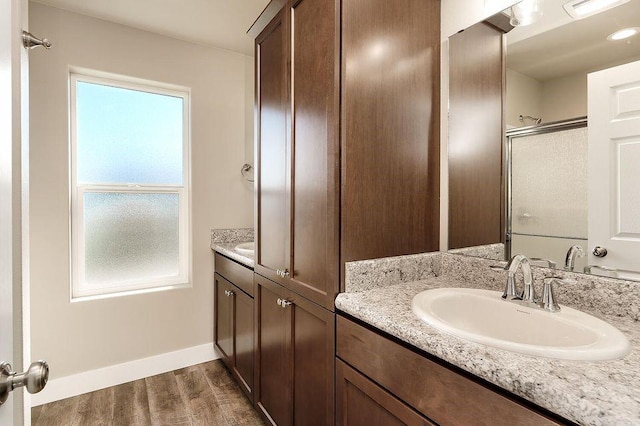 bathroom with wood-type flooring, vanity, and walk in shower