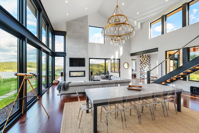 dining room with a wealth of natural light, a fireplace, and a towering ceiling