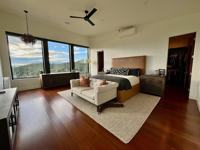 bedroom with ceiling fan with notable chandelier, dark wood-type flooring, and a wall mounted air conditioner