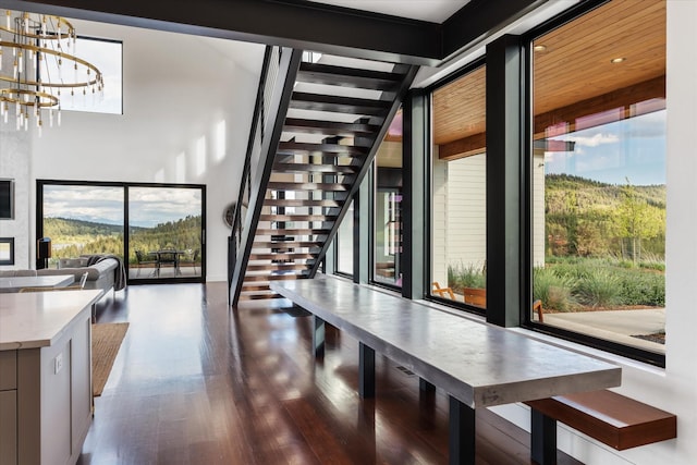 dining room with a wealth of natural light, dark wood-type flooring, and a chandelier