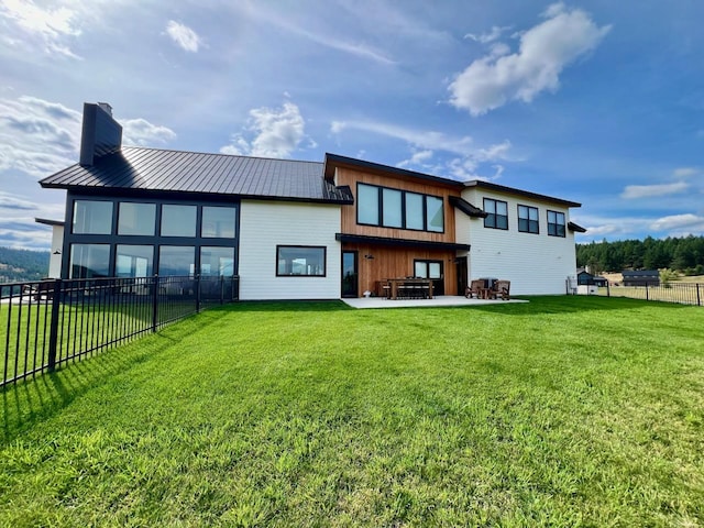 back of house featuring a lawn and a patio area