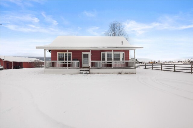 view of snow covered back of property