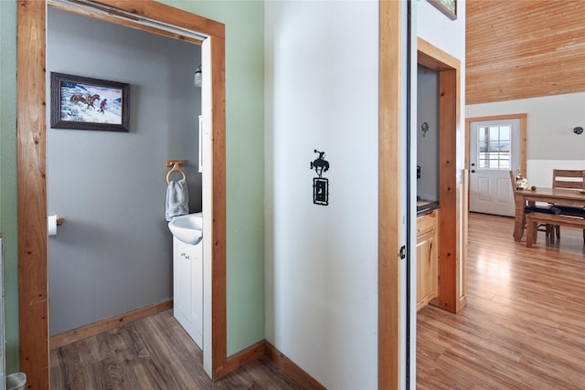 hallway featuring hardwood / wood-style flooring, wood ceiling, and vaulted ceiling