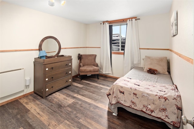 bedroom with radiator and dark hardwood / wood-style flooring