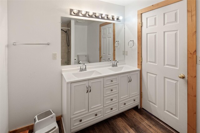 bathroom featuring vanity, toilet, wood-type flooring, and a shower