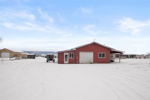 snow covered structure featuring a garage