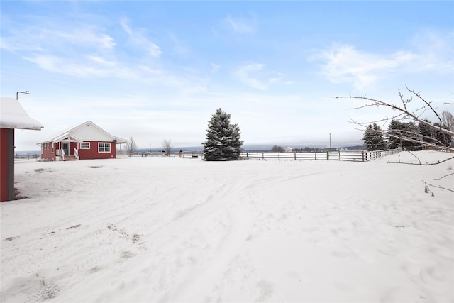 yard layered in snow with a rural view