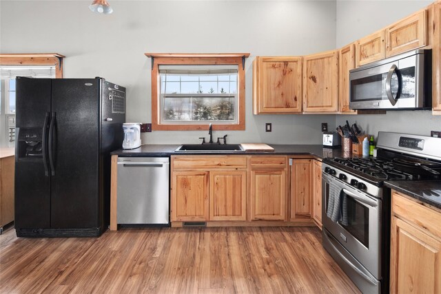 kitchen with hardwood / wood-style floors, light brown cabinets, sink, and stainless steel appliances