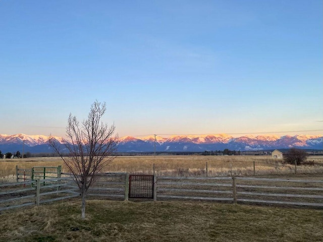 yard at dusk with a mountain view and a rural view