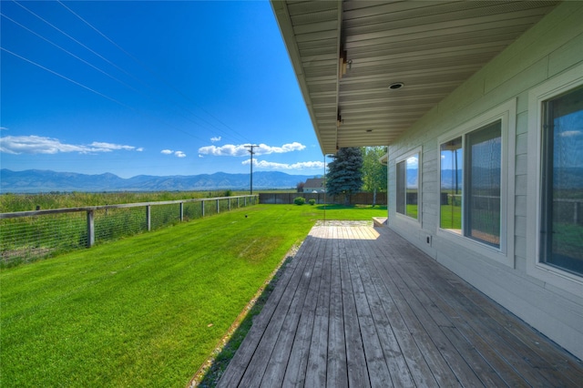 wooden terrace with a mountain view and a yard