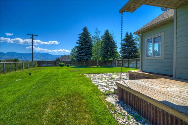 view of yard with a deck with mountain view