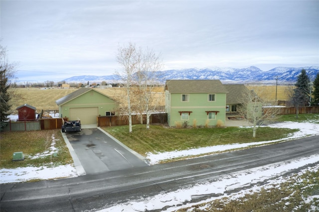 view of front of home with a mountain view, a yard, and a garage