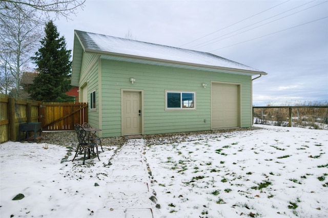 snow covered house with an outbuilding