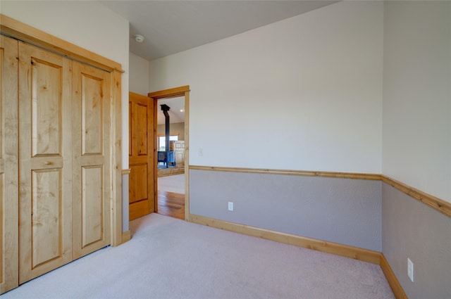 unfurnished bedroom featuring light carpet and a closet