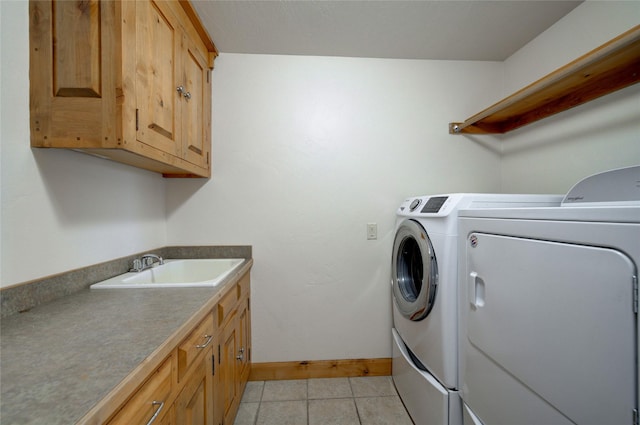 clothes washing area with cabinets, washer and clothes dryer, and sink