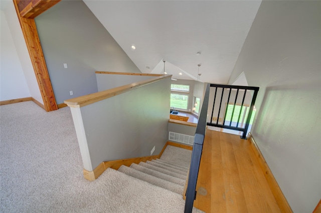 stairway featuring carpet flooring and vaulted ceiling