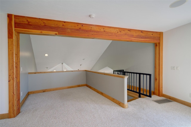 spare room featuring lofted ceiling and light carpet