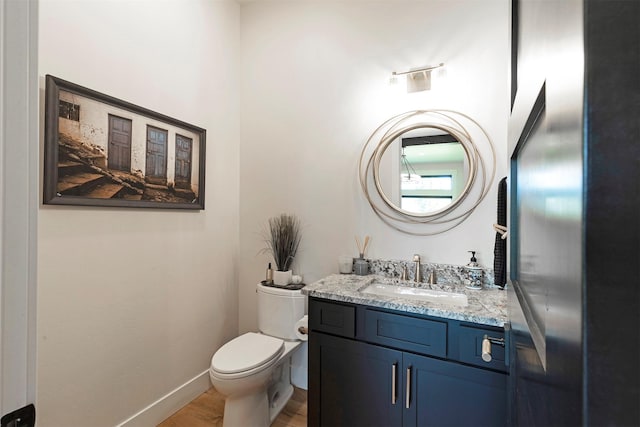 bathroom with wood-type flooring, vanity, and toilet