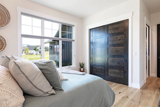 bedroom with light wood-type flooring and multiple windows