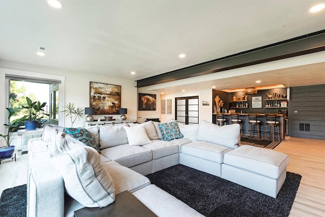 living room featuring indoor bar and light wood-type flooring