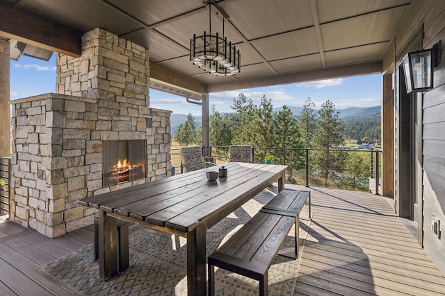 deck featuring a mountain view and an outdoor stone fireplace