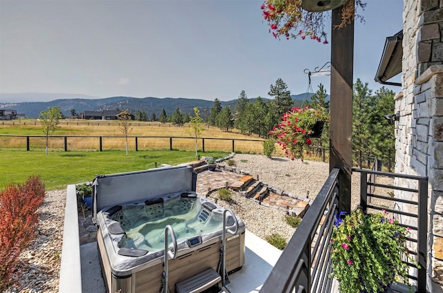 exterior space featuring a mountain view, a rural view, and a hot tub